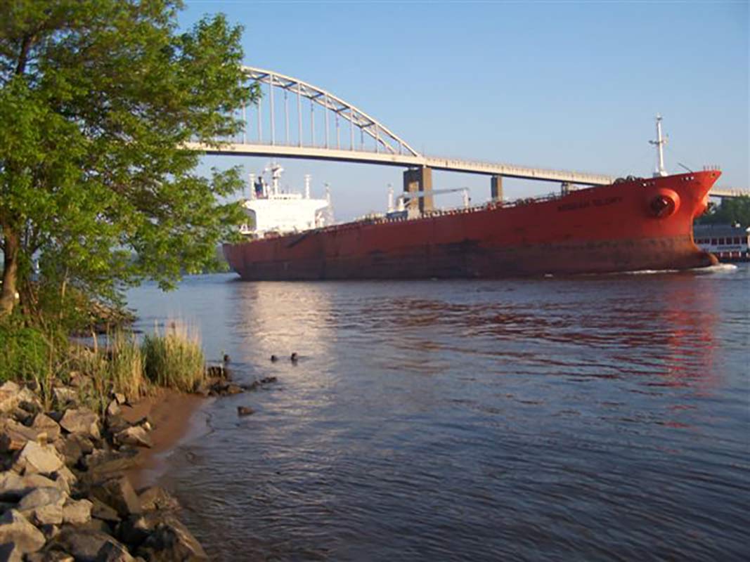 A barge traveling the canal with the bridge in the background